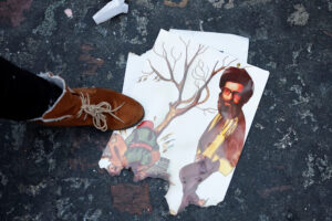 Ένας διαδηλωτής στέκεται πάνω σε μια καμένη φωτογραφία που απεικονίζει τον ανώτατο ηγέτη του Ιράν, Αγιατολάχ Αλί Χαμενεΐ, κατά τη διάρκεια μιας συγκέντρωσης υποστήριξης προς τον ιρανικό λαό εν μέσω των αντικυβερνητικών διαδηλώσεων που μαίνονται σε ολόκληρο το Ιράν, στο Παρίσι της Γαλλίας. Reuters