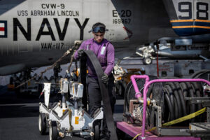 Ο υποπλοίαρχος της Αμερικανικής Ναυτικής Αεροπορίας (Καύσιμα) 3ης τάξης Άντζελ Γκαρσία μεταφέρει έναν σωλήνα καυσίμου στο κατάστρωμα πτήσης του αεροπλανοφόρου USS Abraham Lincoln της Αμερικανικής Ναυτικής Αεροπορίας, κλάσης Nimitz, στην Αραβική Θάλασσα, στις 20 Φεβρουαρίου 2026. Αμερικανική Ναυτική Αεροπορία/Ειδικός Μαζικής Επικοινωνίας Ναύτης Aljay Monzales/Φυλλάδιο μέσω REUTERS