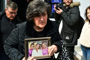 EUROKINISSI - Δίκη για τα Τέμπη - Η γιαγιά της οικογένειας Πλακιά κρατάει τις φωτογραφίες των τριών κοριτσιών της