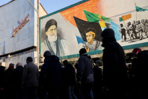 Άνθρωποι περπατούν κοντά σε μια τοιχογραφία με την εικόνα του ανώτατου ηγέτη του Ιράν, Αγιατολάχ Αλί Χαμενεΐ, καθώς συγκεντρώνονται μετά τη δολοφονία του Χαμενεΐ σε ισραηλινές και αμερικανικές επιθέσεις το Σάββατο, στην Τεχεράνη, Ιράν, 1 Μαρτίου 2026. Majid Asgaripour/WANA (West Asia News Agency) μέσω REUTERS