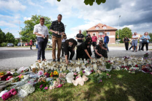 Residents leave flowers and candles at a makeshift memorial outside a shool the day after a sword attack, in Fagersta